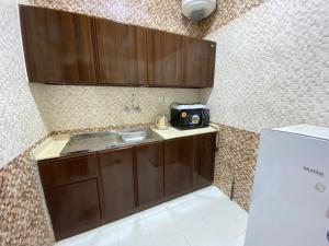 una pequeña cocina con fregadero y nevera. en Qasr Aldabab Housing Units, en Abha