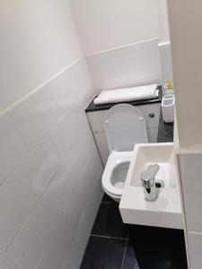 a small bathroom with a toilet and a sink at Large House with 3 Bedrooms house, 5 guests near city/Manu stadiums in Manchester