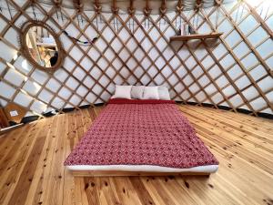 a red bed in a yurt with a mirror at Dzikość Serca - Jurta z widokiem na Tatry in Knurów