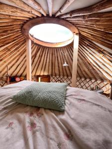 een bed in een yurt met een raam bij Dzikość Serca - Jurta z widokiem na Tatry in Knurów