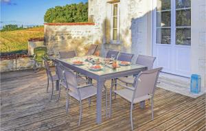 a dining table and chairs on a patio at 4 Bedroom Amazing Home In Champmillon in Champmillon