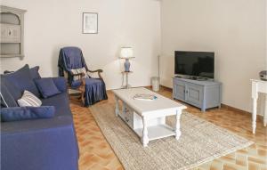 4 Bedroom Amazing Home In Champmillon في Champmillon: غرفة معيشة مع أريكة زرقاء وتلفزيون