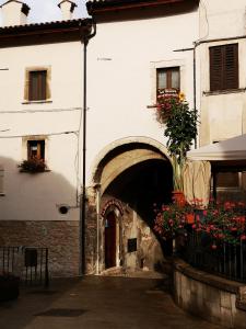 - un bâtiment avec une arche et des fleurs dans l'établissement La Dimora di d'Annunzio, à Scanno