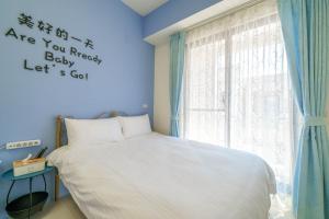 五結鄉的住宿－咫尺民宿，蓝色的卧室设有床和窗户