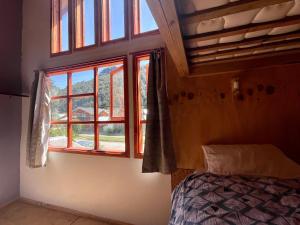 1 dormitorio con cama y ventana en Mirlo’s hostel en Futaleufú