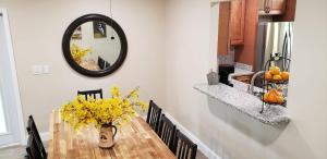 una mesa de comedor con un jarrón de flores amarillas en Little Ridge Ranch-East House Quiet Country Getaway-Pet Friendly!, en Williston
