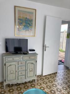 a television on top of a dresser in a room at Asteria in Ouistreham