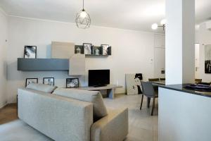 een woonkamer met een bank en een bureau met een televisie bij 4 Passi Mare 2 in Finale Ligure