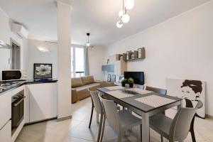 een keuken en een woonkamer met een tafel en stoelen bij 4 Passi Mare 2 in Finale Ligure