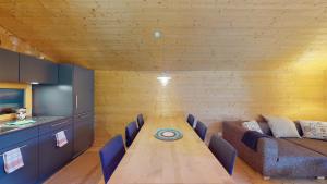 a dining room with a long table and a couch at Stylish architects hut ski lift in Mutten +14 photos