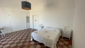 um quarto branco com uma cama e um piso de xadrez em Casa Vacanze Zingari em Minervino Murge