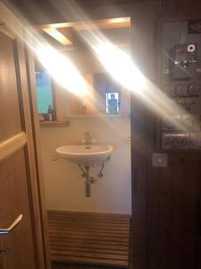 a bathroom with a sink and a light on the wall at Hütte/ Chalet MAZOT ein umgebauter alter Kornspeicher in Verbier