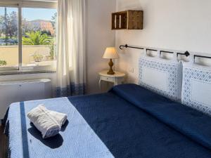 1 dormitorio con cama azul y ventana en La Terrazza Guesthouse, en Olbia