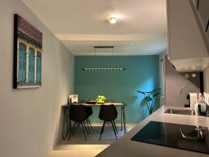 uma cozinha com uma mesa e uma parede azul em Sweetwater Privé Wellness em Oud-Heverlee