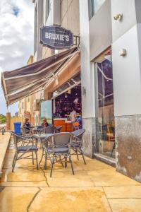 a patio with tables and chairs in front of a building at Rihana Studio & pool in Borg El Arab