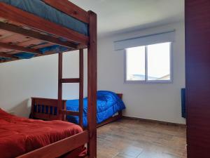 a bedroom with two bunk beds and a window at COMPLEJO LA CASCADA ESQUEL in Esquel