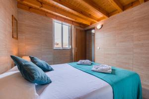1 dormitorio con 1 cama grande con almohadas azules en Chale Bela, en Setúbal