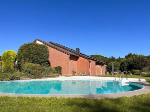 an empty swimming pool in front of a brick building at Clémentine in Theux