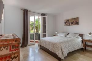 een witte slaapkamer met een bed en een raam bij SF Marbella Luxury Beach Apartment - Jardines de las Golondrinas in Marbella +32 foto's