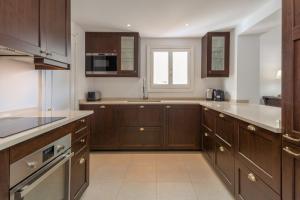 een keuken met houten kasten en een raam bij SF Marbella Luxury Beach Apartment - Jardines de las Golondrinas in Marbella
