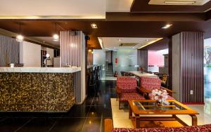a hotel lobby with a bar and red chairs at La Palma - Garden Saigon Hotel Phu My Hung in Ho Chi Minh City
