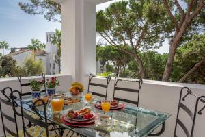een tafel met ontbijtproducten op een balkon met bomen bij SF Marbella Luxury Beach Apartment - Jardines de las Golondrinas in Marbella