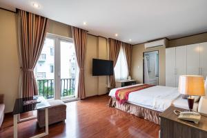 Cette chambre d'hôtel comprend un lit et un balcon. dans l'établissement La Palma - Garden Saigon Hotel Phu My Hung, à Hô-Chi-Minh-Ville