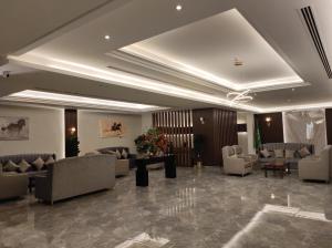 a lobby with couches and chairs in a building at Brzeen Hotel Riyadh in Riyadh