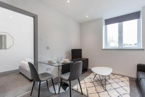 a living room with a table and chairs and a couch at Lovely 1 Bedroom Apartment Leeds in Leeds