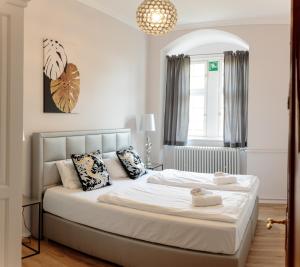een slaapkamer met een groot bed met witte lakens en kussens bij Schlosshotel Erwitte in Erwitte