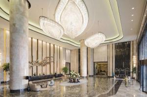 a lobby of a hotel with large chandeliers at Wanda Realm Changzhou in Changzhou