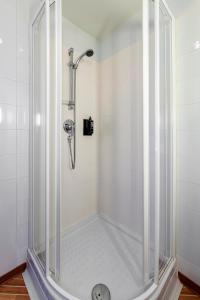 y baño con ducha y mampara de cristal. en Ibis Madrid Getafe en Getafe
