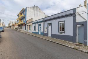 un edificio azul y blanco al lado de una calle en Chale Bela, en Setúbal