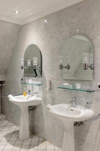 een badkamer met 2 wastafels en een spiegel bij Schlosshotel Erwitte in Erwitte