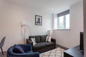 Amazing 1 Bedroom Apartment Leeds في ليدز: غرفة معيشة مع أريكة وكرسي