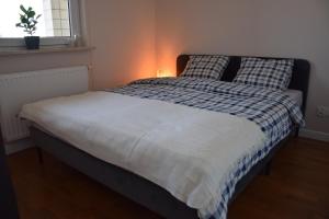 a bedroom with a bed with a blue and white comforter at Warsaw City Break in Pruszków