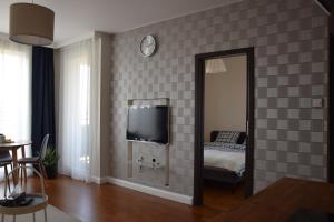 a living room with a mirror and a tv at Warsaw City Break in Pruszków