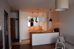 a kitchen with white cabinets and a counter top at Warsaw City Break in Pruszków
