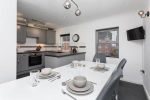 a kitchen and dining room with a white table and chairs at Great Park Townhouse in Preston