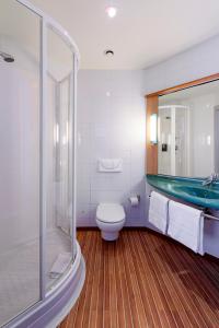 a bathroom with a toilet and a shower and a tub at Ibis Madrid Getafe in Getafe