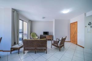 sala de estar con sillas, mesa y puerta en Aluguel Apartamento 2 quartos 100m Mar Bombas/SC, en Bombinhas