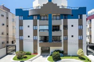 un edificio de apartamentos con fachada azul en Aluguel Apartamento 2 quartos 100m Mar Bombas/SC, en Bombinhas