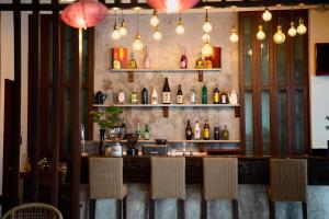 a bar with chairs and bottles on the wall at Chirin Home ฌิรินทร์โฮม in Chiang Mai