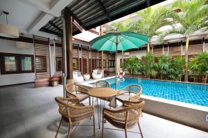 a patio with a table and chairs and a pool at Chirin Home ฌิรินทร์โฮม in Chiang Mai