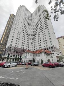 Un gran edificio blanco con coches aparcados en un estacionamiento. en Exclusive Studio/ 1~4pax/ Gurney/ Mansion One, en George Town