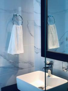 y baño con lavabo, espejo y toallas. en 2BR Cozy Villa 30 in Sosua Ocean Village, en Sosúa