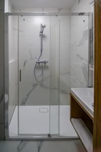 a glass shower in a bathroom with a sink at Hotel Duet in Chełm