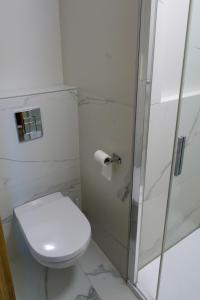 a white bathroom with a toilet and a shower at Hotel Duet in Chełm