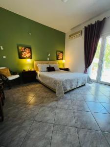 a bedroom with a bed and a green wall at Villa Domenico in Vryses