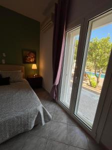 a bedroom with a bed and a large window at Villa Domenico in Vryses